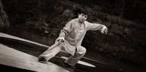 taiji quan oder tai chi chuan. Chinese übt diese Bewegungsform in Tiefen Stellunge und traditionellem Gewand aus.
